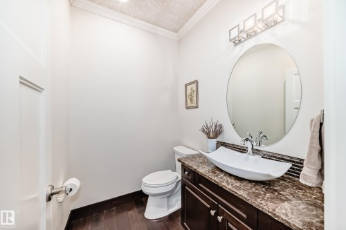 Bathroom with vanity, crown molding, dark wood-style floors, and a textured ceiling - 6 Wade Avenue, Leduc, AB - Indoor Photo Showing Bathroom