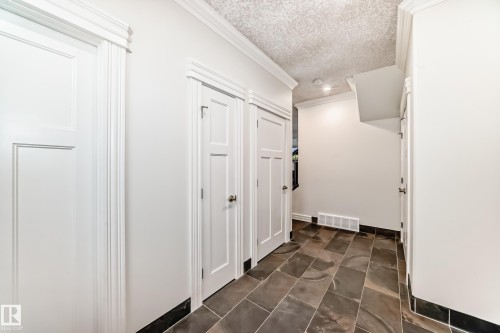 Hallway with a textured ceiling and crown molding - 6 Wade Avenue, Leduc, AB - Indoor Photo Showing Other Room