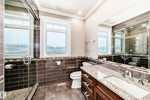 Bathroom featuring vanity, a stall shower, tile walls, crown molding, and dark tile patterned floors - 6 Wade Avenue, Leduc, AB - Indoor Photo Showing Bathroom