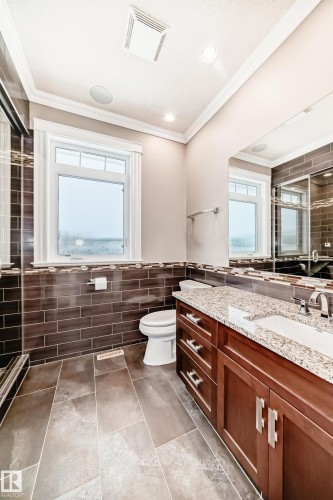 Bathroom featuring a shower stall, tile walls, ornamental molding, vanity, and wainscoting - 6 Wade Avenue, Leduc, AB - Indoor Photo Showing Bathroom