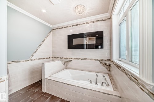 Full bath with tile walls, a bath, ornamental molding, recessed lighting, and wainscoting - 6 Wade Avenue, Leduc, AB - Indoor Photo Showing Bathroom