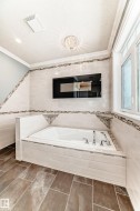 Bathroom with a bath, tile walls, ornamental molding, and tile patterned floors - 
