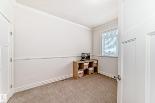 Spare room featuring ornamental molding and light colored carpet - 6 Wade Avenue, Leduc, AB - Indoor Photo Showing Other Room