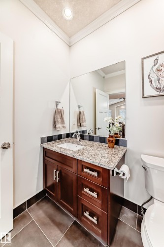 Bathroom with vanity, ornamental molding, dark tile patterned floors, and a textured ceiling - 6 Wade Avenue, Leduc, AB - Indoor Photo Showing Bathroom