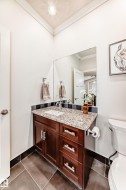 Bathroom with vanity, ornamental molding, dark tile patterned floors, and a textured ceiling - 