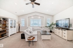 Living area with light colored carpet, lofted ceiling, a ceiling fan, and recessed lighting - 