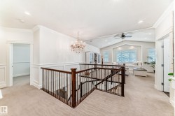 Hall with an upstairs landing, a chandelier, light carpet, lofted ceiling, and recessed lighting - 