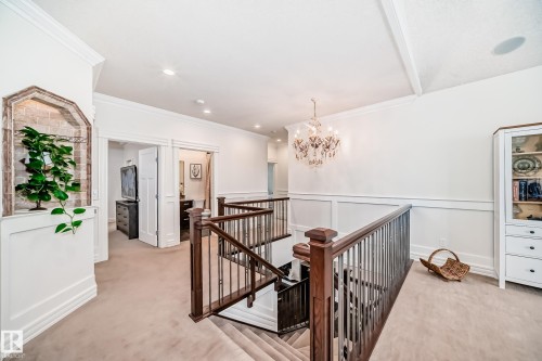 Hallway featuring an upstairs landing, light carpet, a chandelier, ornamental molding, and wainscoting - 6 Wade Avenue, Leduc, AB - Indoor Photo Showing Other Room
