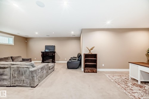 Living room with a fireplace, light colored carpet, and recessed lighting - 6 Wade Avenue, Leduc, AB - Indoor Photo Showing Basement