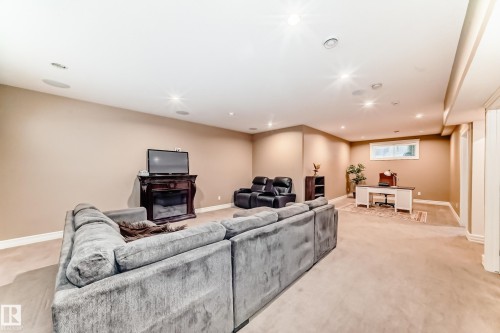 Living area featuring a desk, recessed lighting, light colored carpet, and a glass covered fireplace - 6 Wade Avenue, Leduc, AB - Indoor With Fireplace
