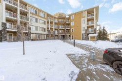 Snow covered property with a view of apartment building / complex - 