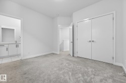 Unfurnished bedroom with light carpet, a closet, and ensuite bath - 