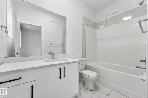 Bathroom featuring vanity, shower / tub combination, and light marble finish flooring - #5 15805 97 Ave, Edmonton, AB - Indoor Photo Showing Bathroom