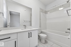 Bathroom featuring vanity, shower / tub combination, and light marble finish flooring - 