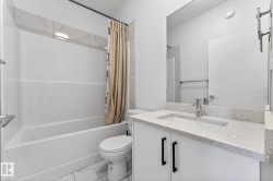 Bathroom with vanity, shower / bath combo with shower curtain, and marble look tile flooring - 