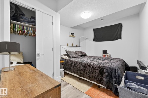 Bedroom featuring a closet, a textured ceiling, and light wood-type flooring - #5 15805 97 Ave, Edmonton, AB - Indoor Photo Showing Bedroom