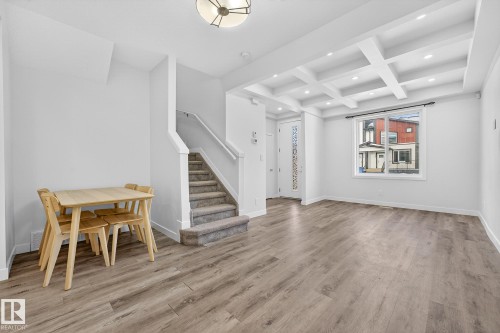 Dining area with coffered ceiling, light wood finished floors, beamed ceiling, stairway, and recessed lighting - #5 15805 97 Ave, Edmonton, AB - Indoor