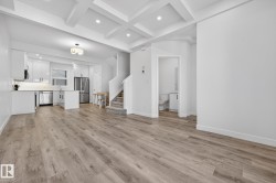 Unfurnished living room featuring stairway, recessed lighting, beam ceiling, light wood finished floors, and coffered ceiling - 
