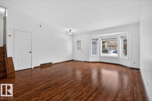 Unfurnished living room with dark wood-style flooring and a textured ceiling - 2516 42 Street, Edmonton, AB - Indoor Photo Showing Other Room