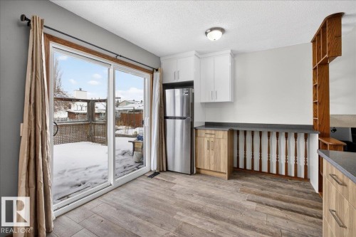 Kitchen featuring freestanding refrigerator, dark countertops, a textured ceiling, light wood-style floors, and open shelves - 2516 42 Street, Edmonton, AB - Indoor