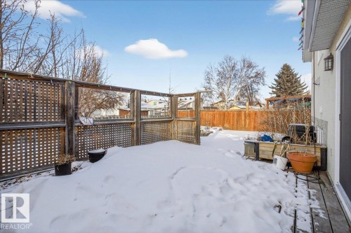 Yard layered in snow featuring a fenced backyard and a deck - 2516 42 Street, Edmonton, AB - Outdoor With Deck Patio Veranda