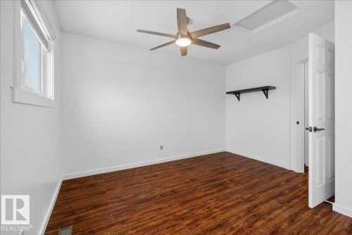 Unfurnished room featuring dark wood finished floors, attic access, a ceiling fan, and a textured ceiling - 2516 42 Street, Edmonton, AB - Indoor Photo Showing Other Room