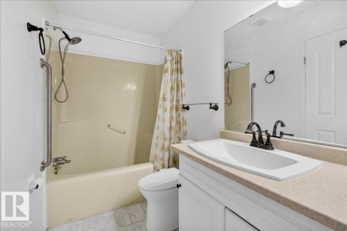 Bathroom featuring vanity and shower / bath combo with shower curtain - 2516 42 Street, Edmonton, AB - Indoor Photo Showing Bathroom