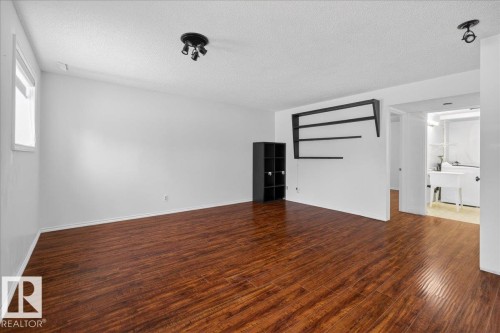 Unfurnished room featuring dark wood finished floors and a textured ceiling - 2516 42 Street, Edmonton, AB - Indoor Photo Showing Other Room