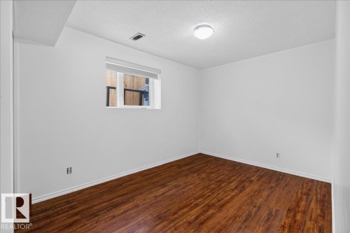 Spare room featuring a textured ceiling and dark wood-style flooring - 2516 42 Street, Edmonton, AB - Indoor Photo Showing Other Room