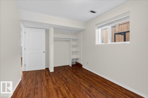 Unfurnished bedroom with dark wood finished floors, a closet, and a textured ceiling - 2516 42 Street, Edmonton, AB - Indoor Photo Showing Other Room