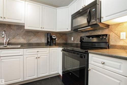 Kitchen with black appliances, white cabinetry, a textured ceiling, and backsplash - 2315 Lemieux Place, Edmonton, AB - Indoor Photo Showing Kitchen With Double Sink
