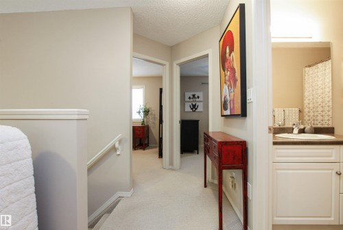 Corridor featuring an upstairs landing, light colored carpet, and a textured ceiling - 2315 Lemieux Place, Edmonton, AB - Indoor