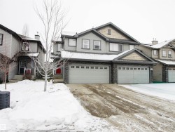 View of front of property with stone siding and a garage - 