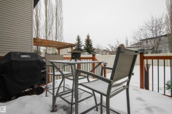 Snow covered deck featuring a grill and outdoor dining space - 