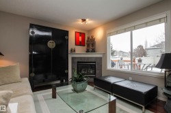Living area featuring a tiled fireplace, wood finished floors, and a textured ceiling - 
