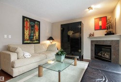 Living room with a textured ceiling, wood finished floors, and a fireplace - 