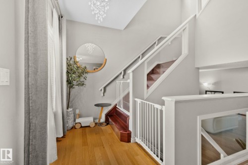 Staircase with wood finished floors, a high ceiling, and a chandelier - 46 13825 155 Avenue, Edmonton, AB - Indoor Photo Showing Other Room