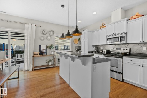 Kitchen with stainless steel appliances, a breakfast bar area, white cabinets, pendant lighting, and recessed lighting - 46 13825 155 Avenue, Edmonton, AB - Indoor Photo Showing Kitchen With Upgraded Kitchen