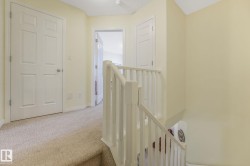 Corridor featuring an upstairs landing and carpet floors - 
