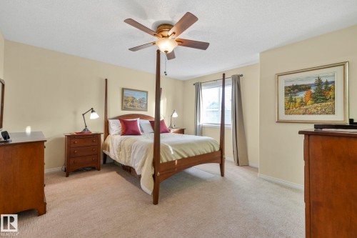Bedroom featuring light carpet, ceiling fan, and a textured ceiling - 23 4755 Terwillegar Common, Edmonton, AB - Indoor Photo Showing Bedroom