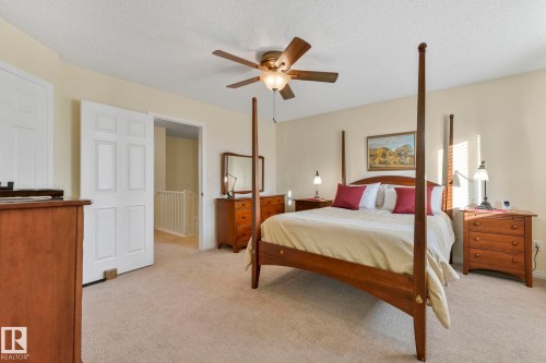 Bedroom featuring light carpet, a ceiling fan, and a textured ceiling - 23 4755 Terwillegar Common, Edmonton, AB - Indoor Photo Showing Bedroom