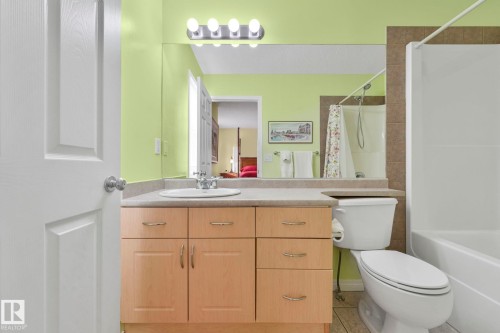 Bathroom featuring vanity, shower / tub combo with curtain, and light tile patterned floors - 23 4755 Terwillegar Common, Edmonton, AB - Indoor Photo Showing Bathroom