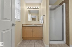 Bathroom featuring a shower stall, vanity, and light tile patterned floors - 