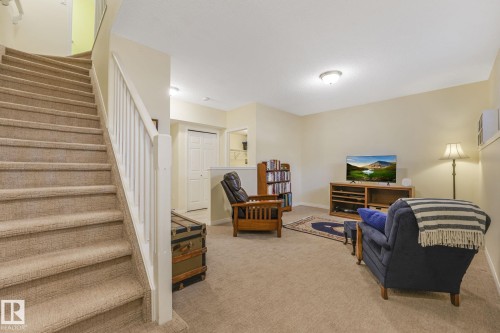 Living area with light colored carpet and stairs - 23 4755 Terwillegar Common, Edmonton, AB - Indoor Photo Showing Other Room