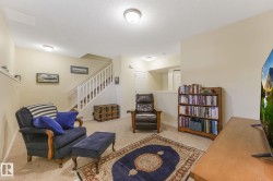 Living area with carpet, a textured ceiling, and stairway - 