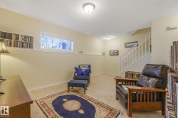 Living area featuring carpet flooring, stairway, and a textured ceiling - 