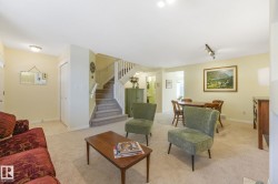 Living area featuring stairway, light colored carpet, and rail lighting - 