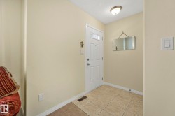 Foyer with light tile patterned flooring and a textured ceiling - 