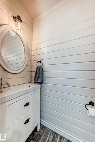 Bathroom featuring vanity, wood walls, and dark wood finished floors - 18931 80 Avenue, Edmonton, AB - 