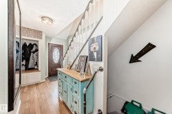 Entryway featuring stairs, light wood-type flooring, and a textured ceiling - 